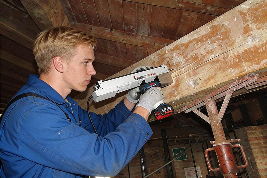 empleado detectando carcoma con un resitografo que mide la resistencia mecanica de la madera